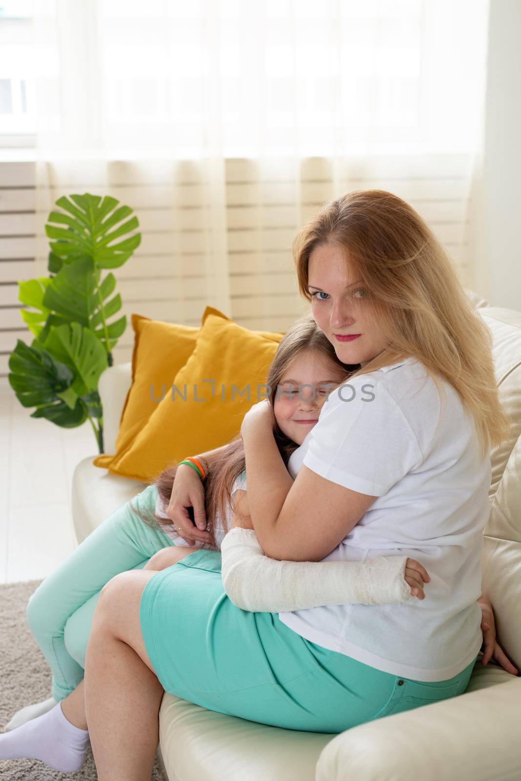 Child with broken arm and gypsum spend time at home with mother. Childhood illnesses, a positive outlook and recovery