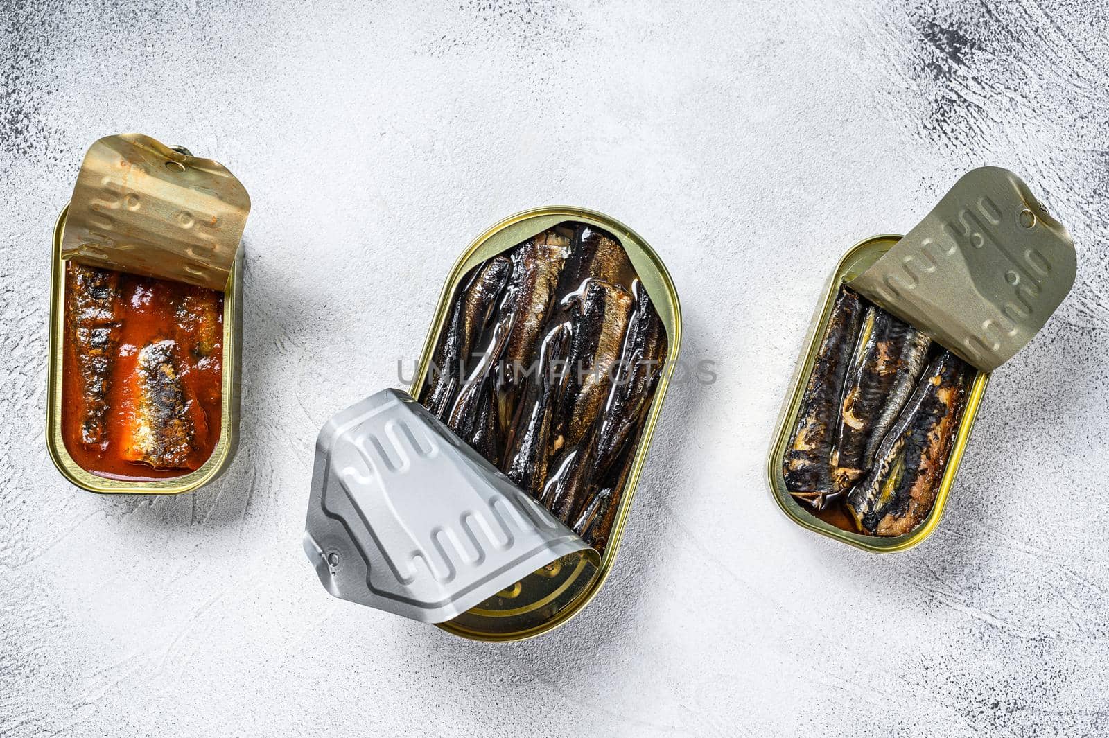 Assorted canned fish in a tin sardine, smoked sardine, mackerel. Grey wooden background. Top view.