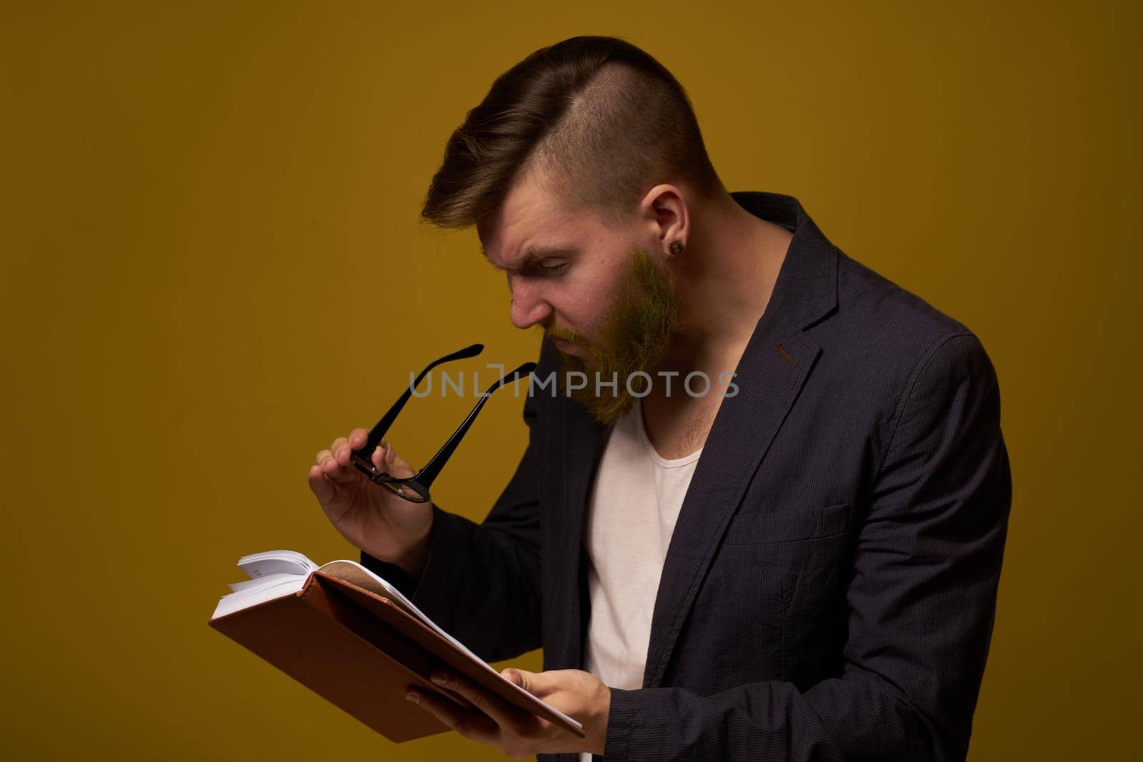 bearded man in a black jacket with a book in his hands education. High quality photo