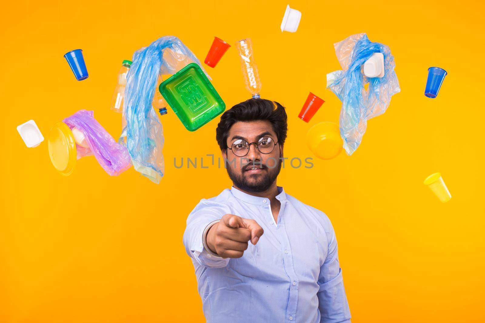 Plastic recycling problem, ecology and environmental disaster concept - Indian man point on you on yellow background.