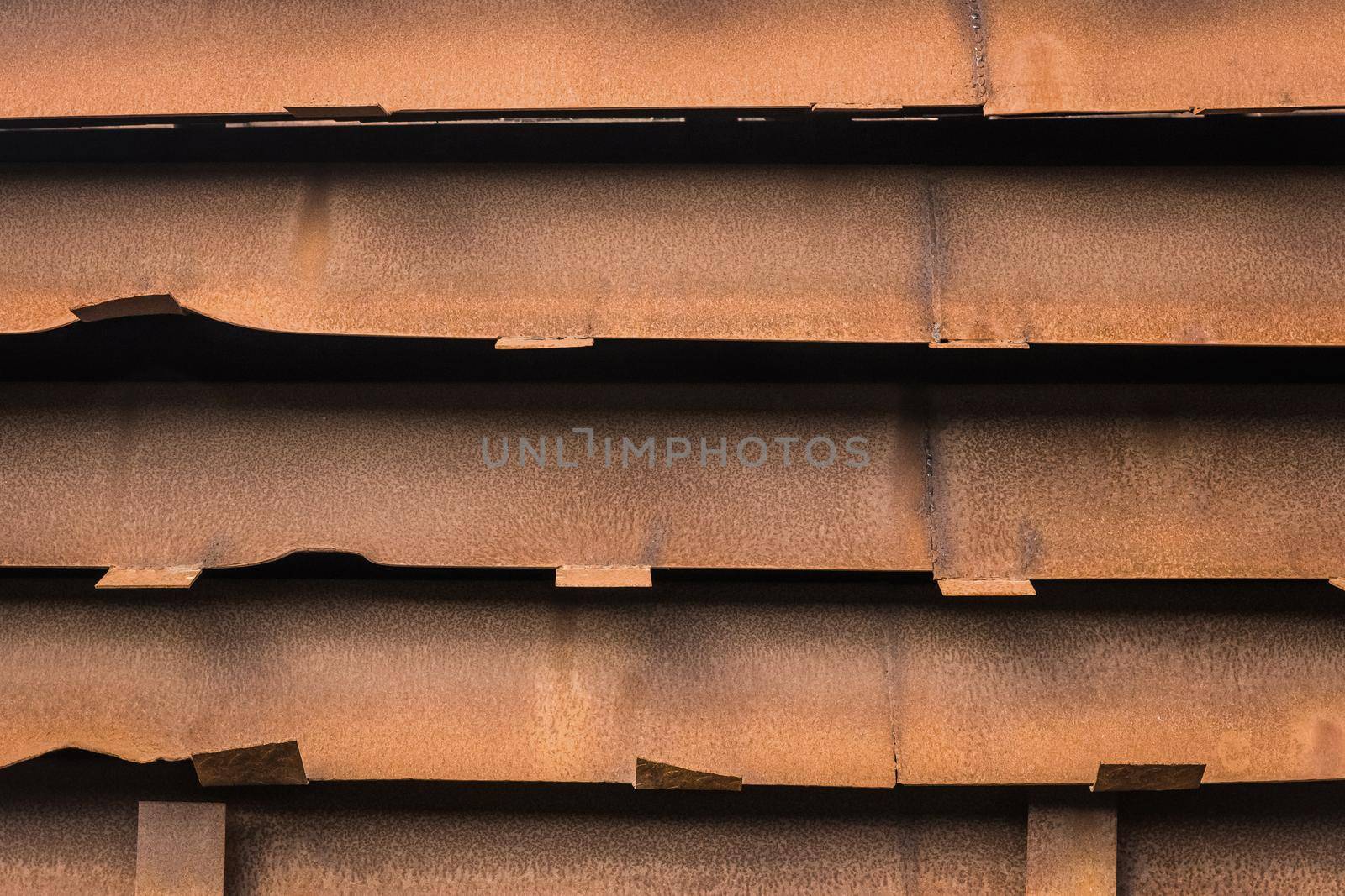 Storage in an open warehouse of old rusty metal materials or structures.