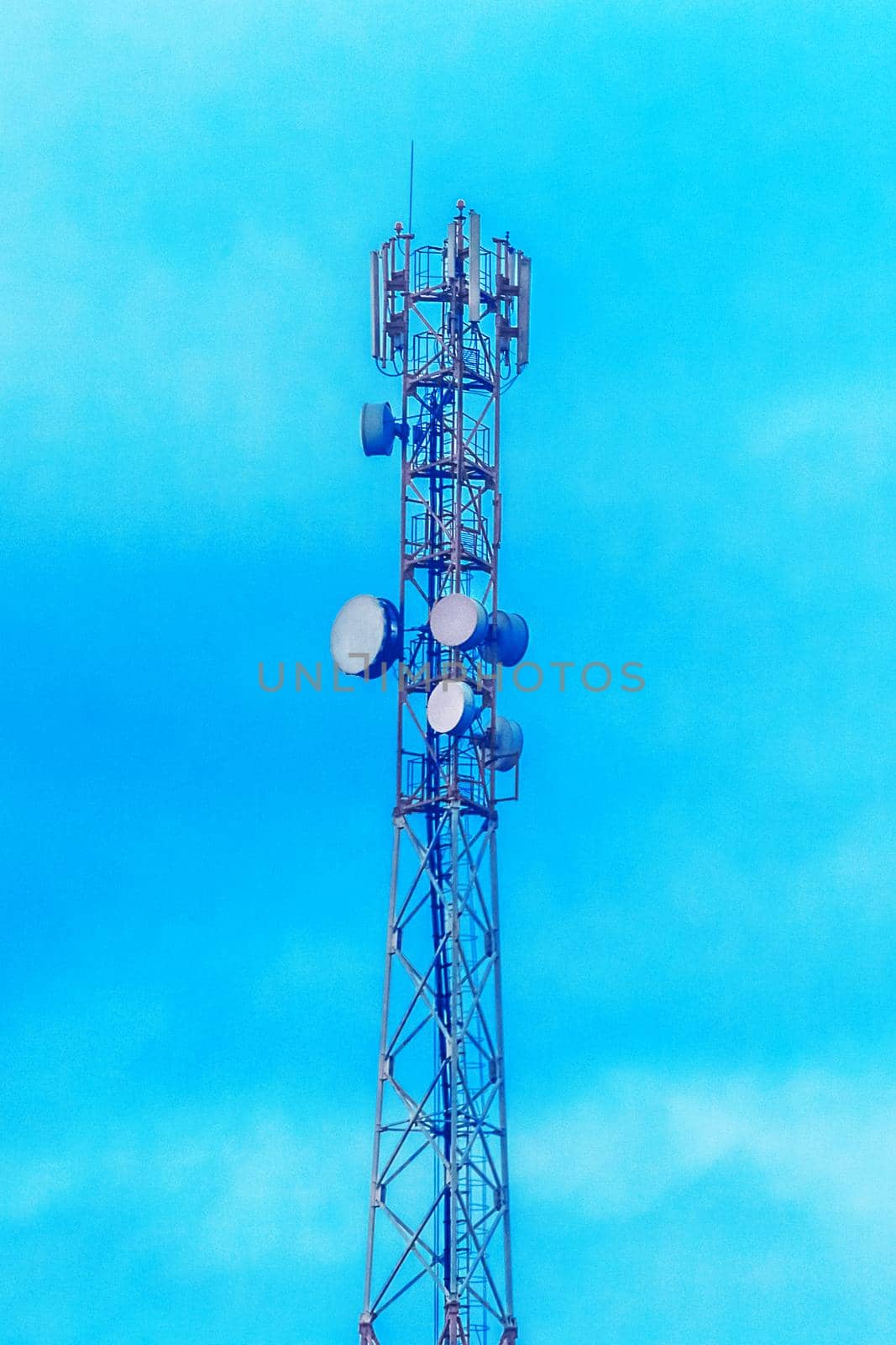 Mobile techology telecommunications network tower on a background of blue sky.