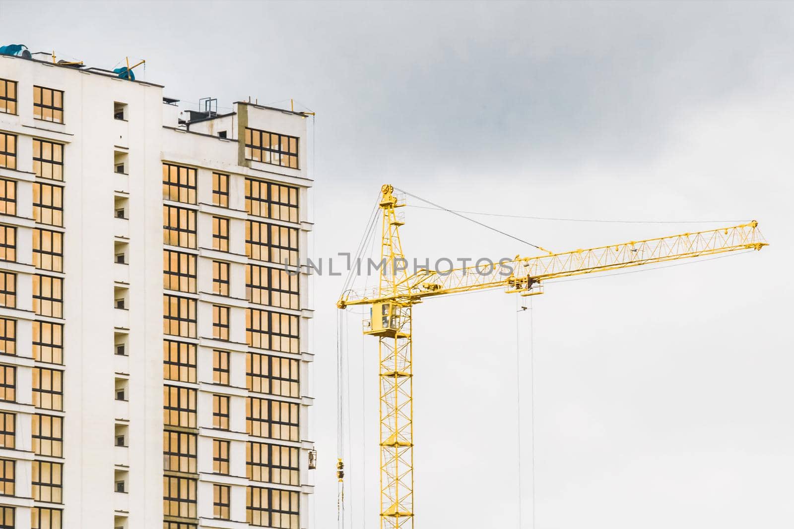 Industrial tower crane build a new modern city building on an construction site. Building development and work of urban architecture.