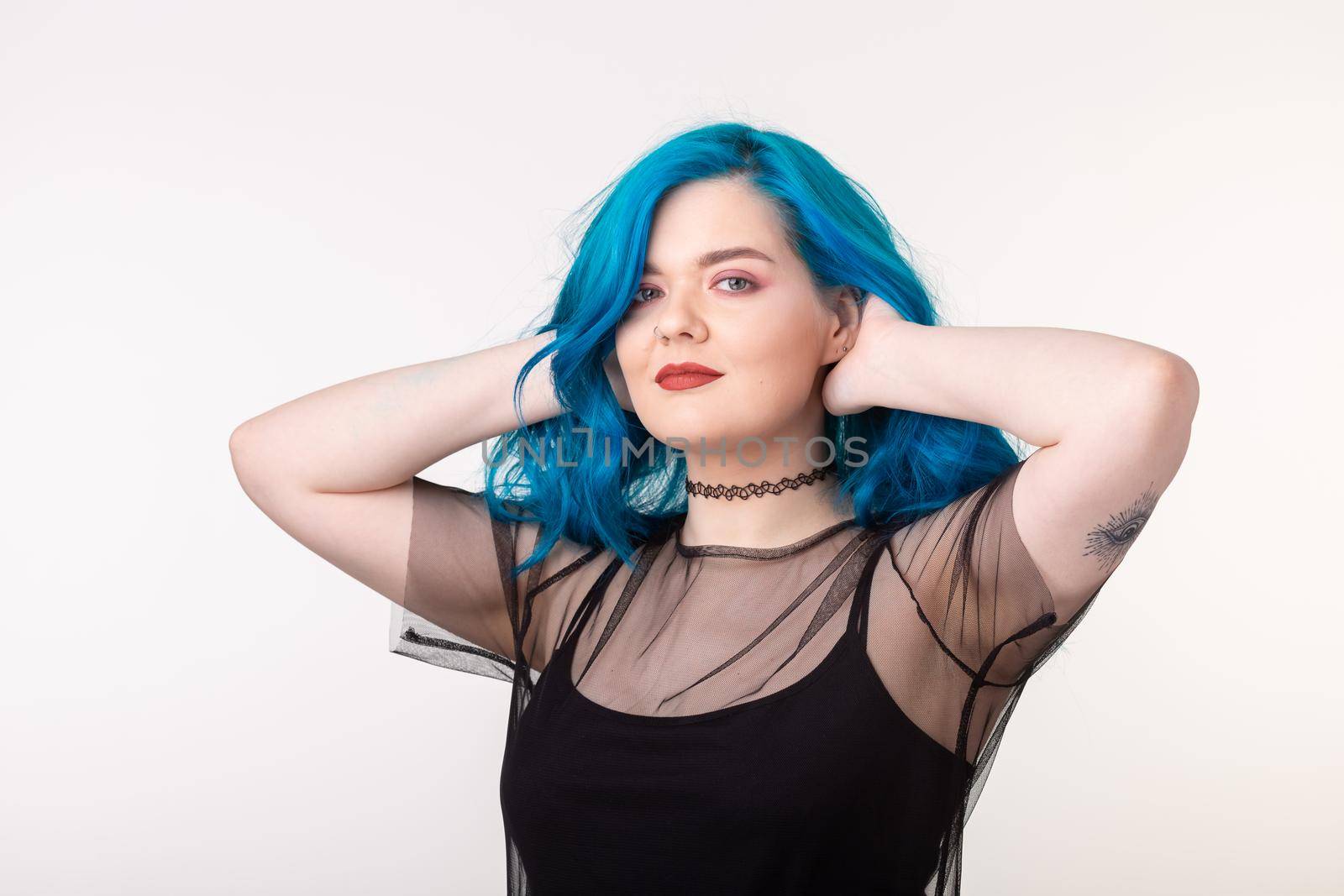 People and fashion concept - Beautiful woman with blue hair posing over white background.