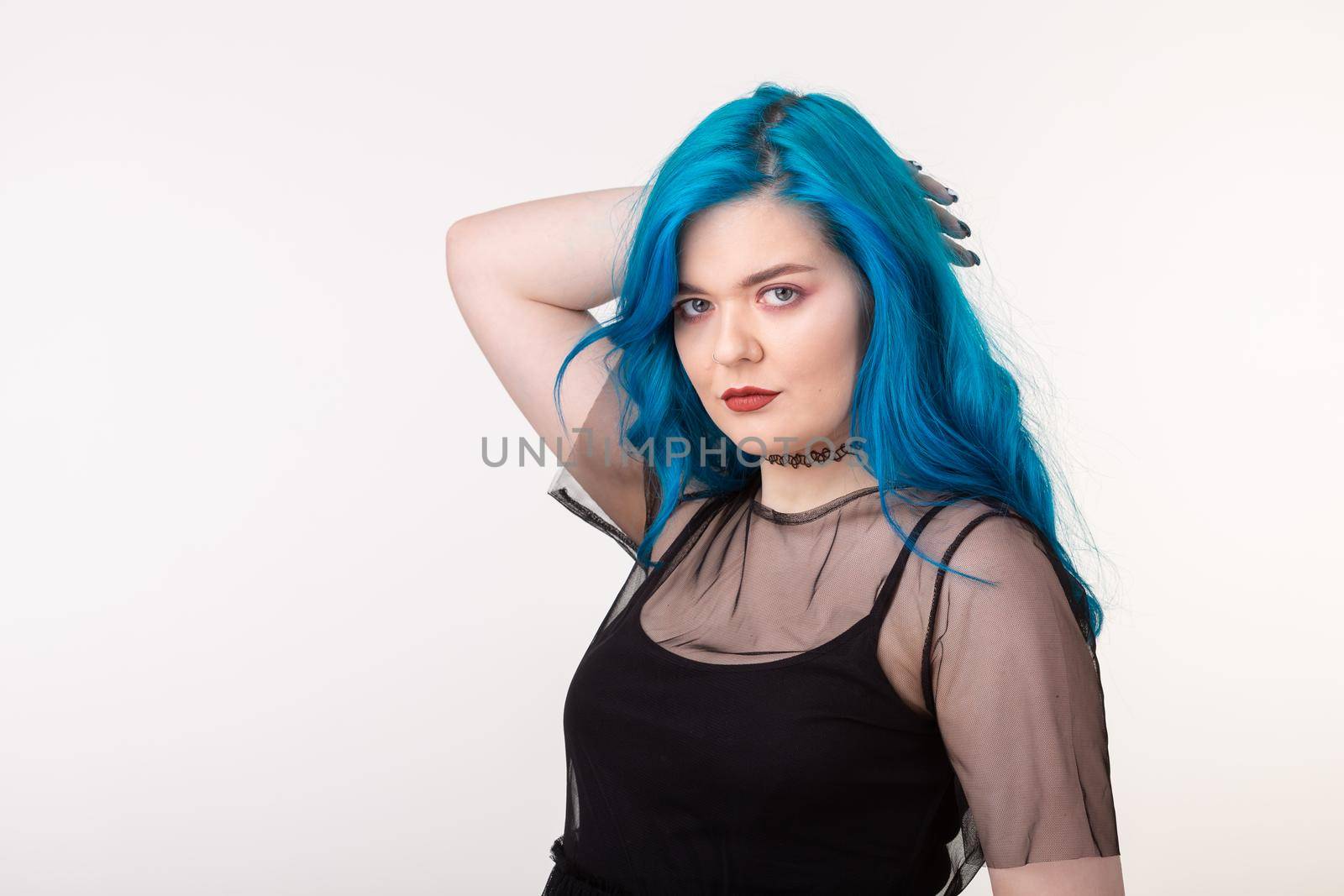 People and fashion concept - Beautiful woman with blue hair posing over white background.