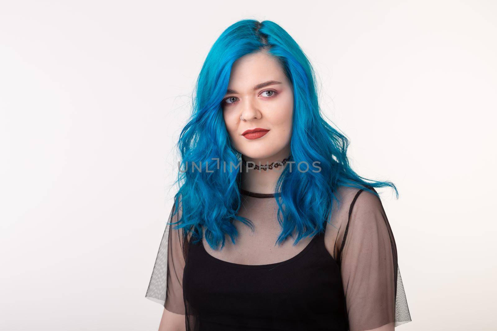 People and fashion concept - Beautiful woman with blue hair posing over white background.