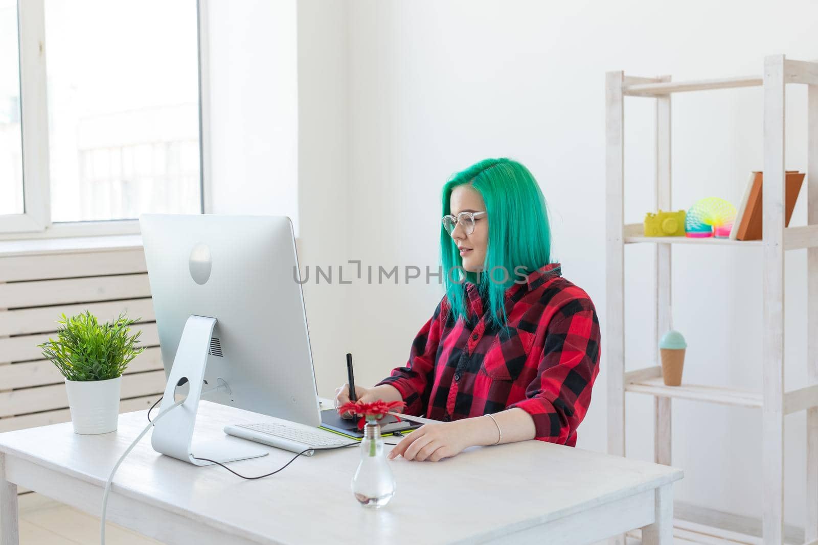 Creative, illustrator and designer concept - happy woman with green hair is drawing a project.