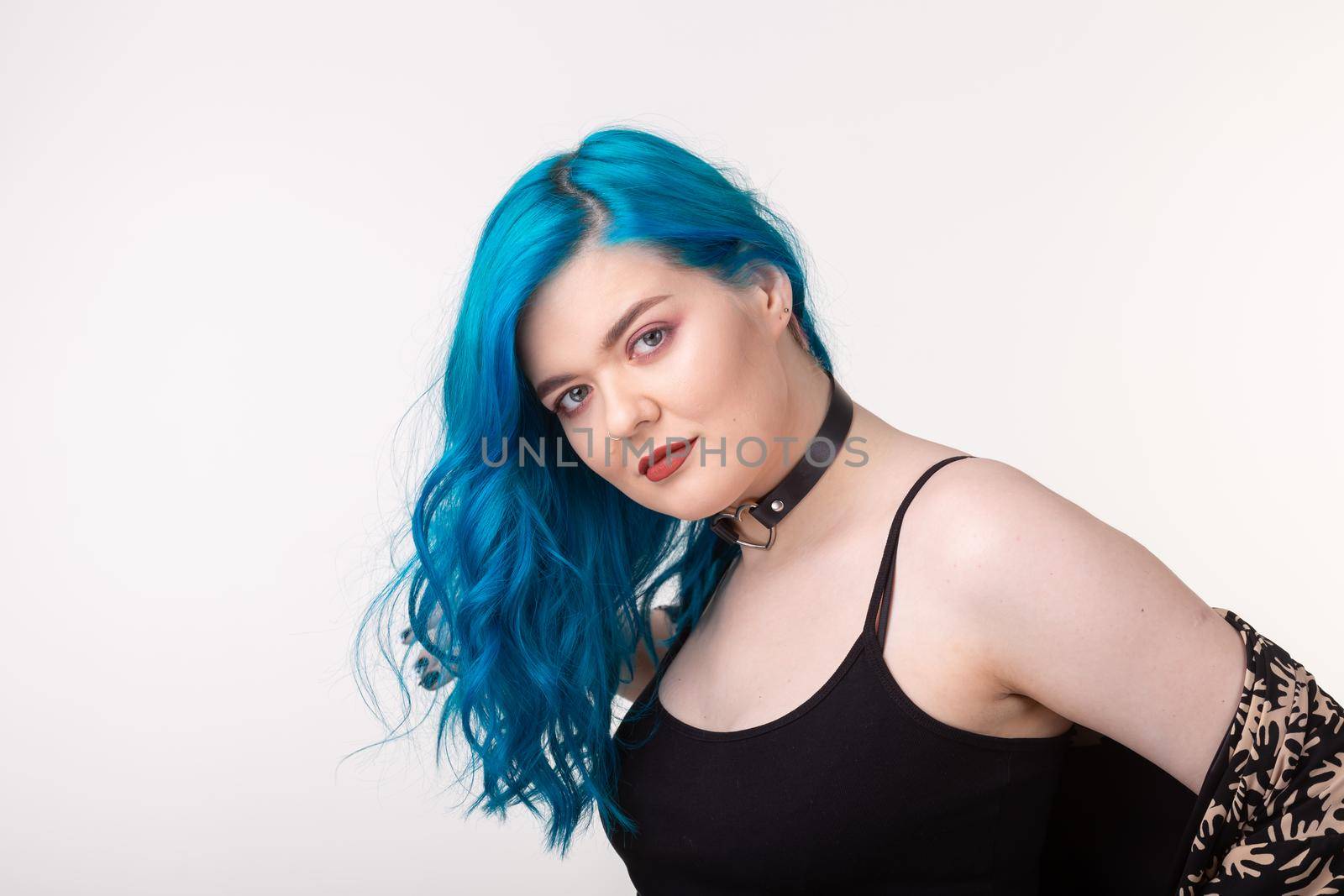 People and fashion concept - Beautiful woman with blue hair posing over white background.