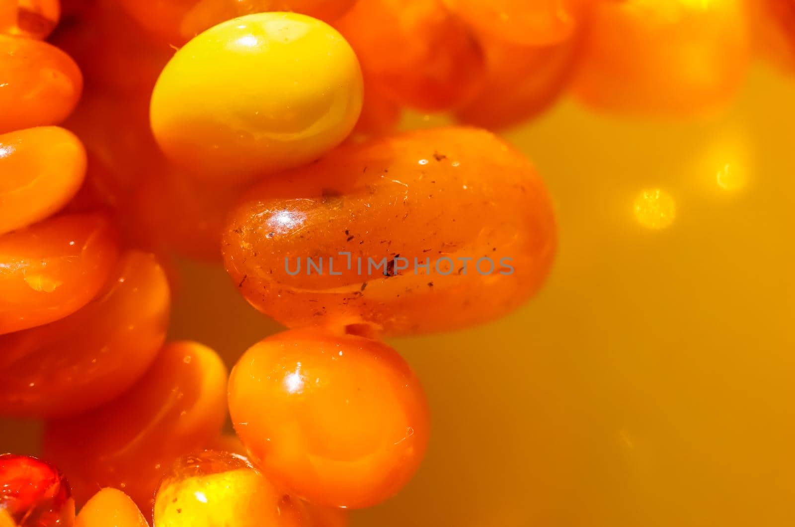 Sunny beads of fire amber. Natural gemstone background, jewelry concept by Olayola