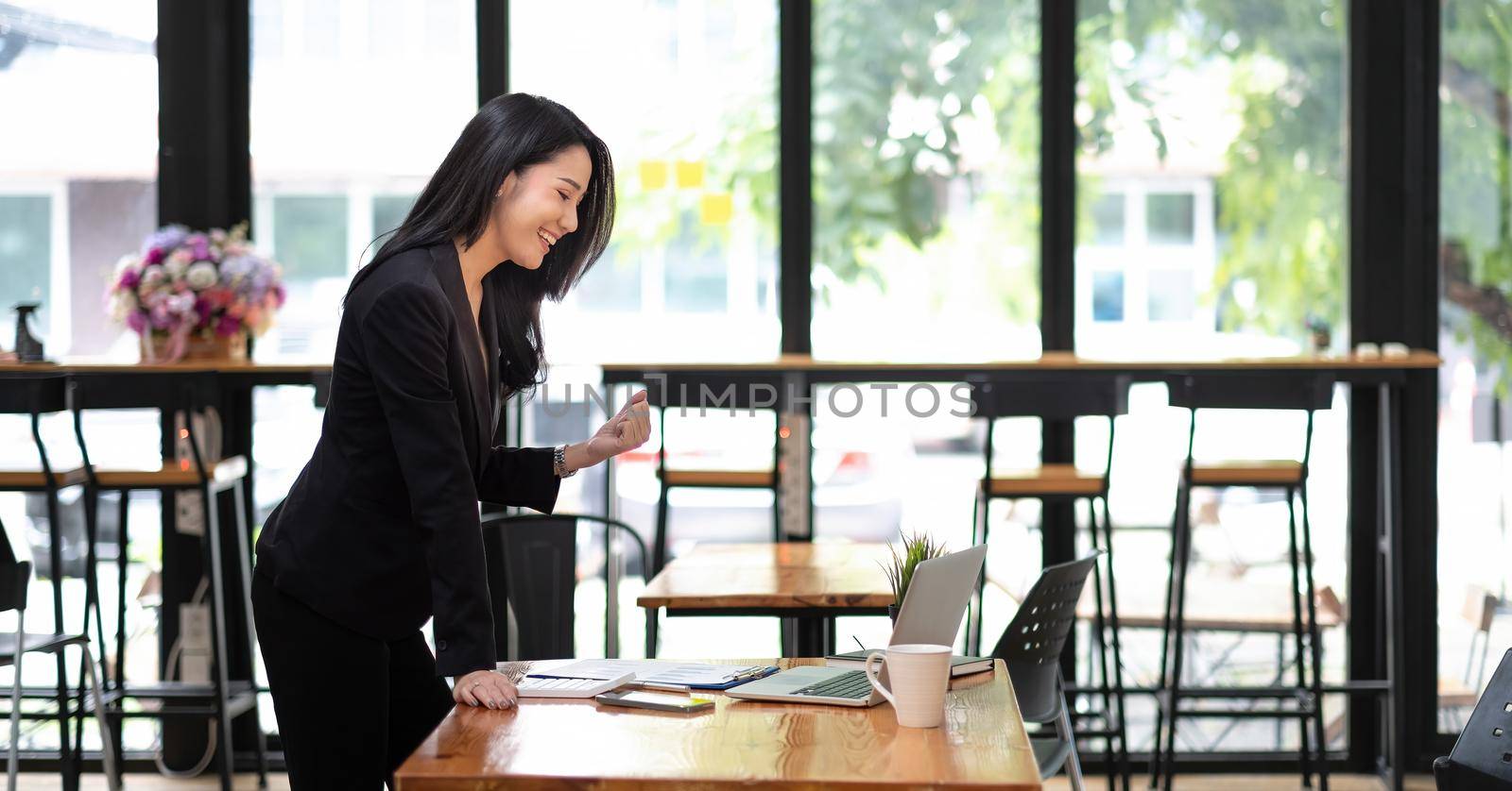 Happy excited successful businesswoman triumphing in office, Asian woman working with laptop computer for business financial concept by nateemee