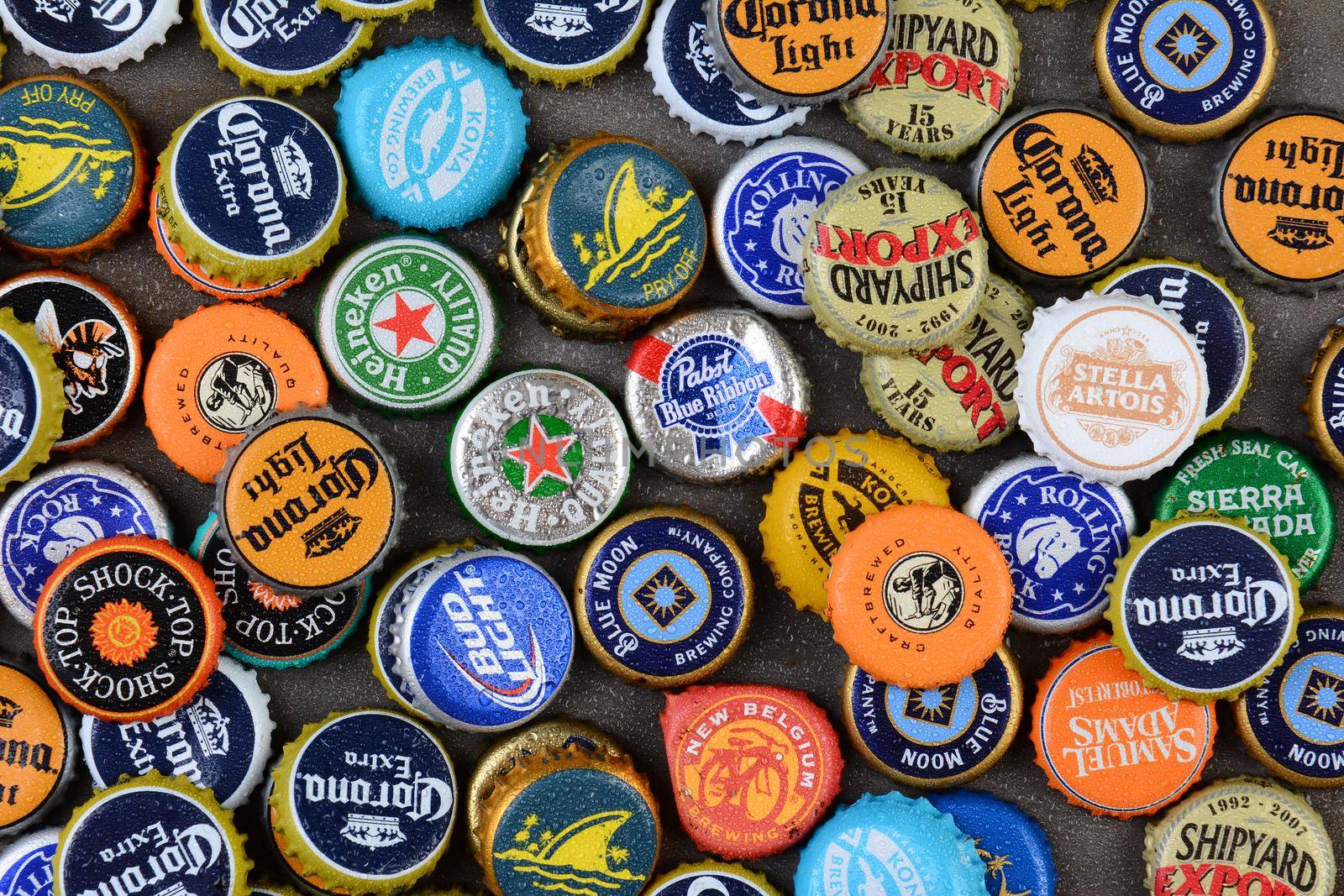 IRVINE, CA - JUNE 16, 2014: High angle shot of a group of assorted beer bottle caps. The caps include both domestic and imported brands.