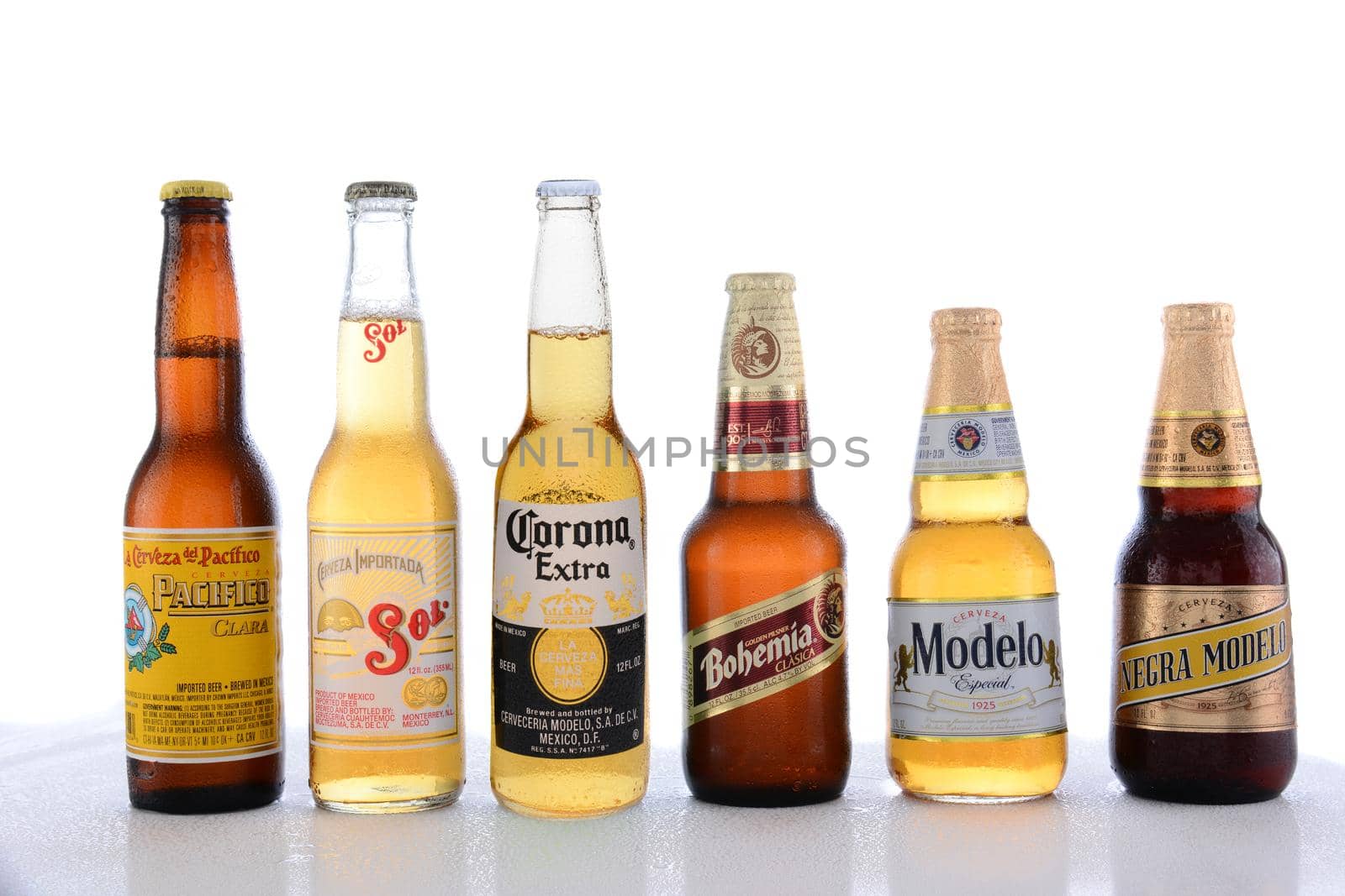 IRVINE, CA - JUNE 14, 2015: Popular Mexican Beers. Pacifico, Sol, Corona, Bohemia and Modelo beer bottles on a wet table with reflections. 