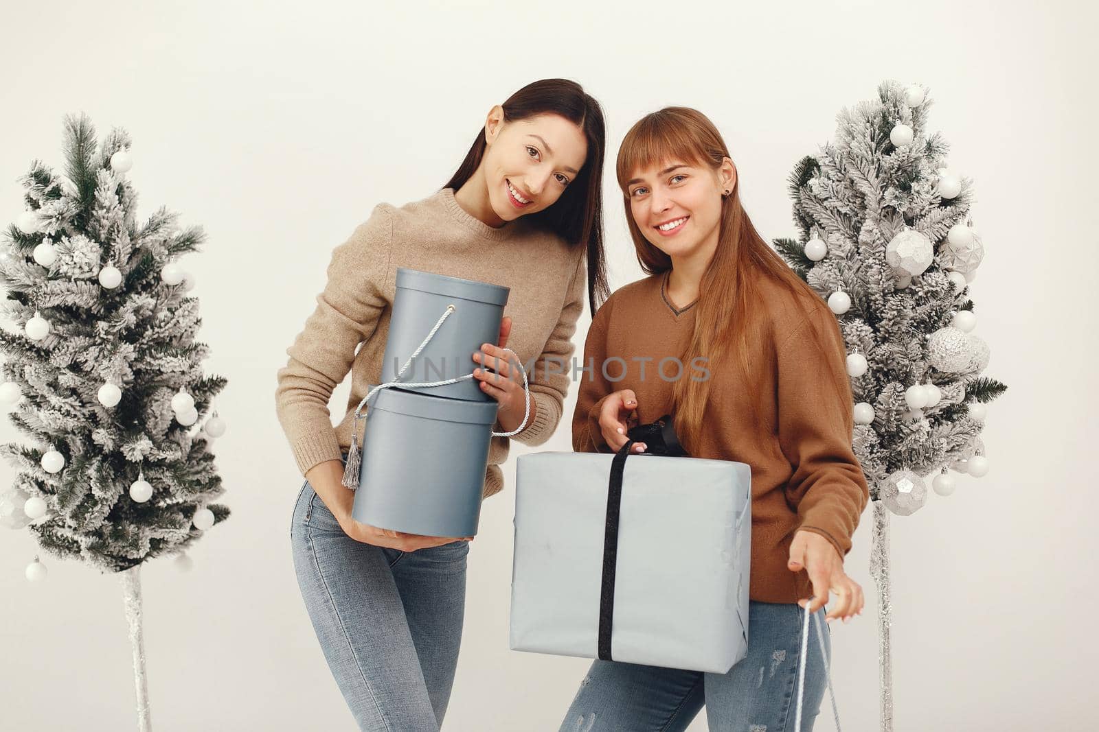 Women with presents. Girl in a brown sweater. Ladies in a studio.