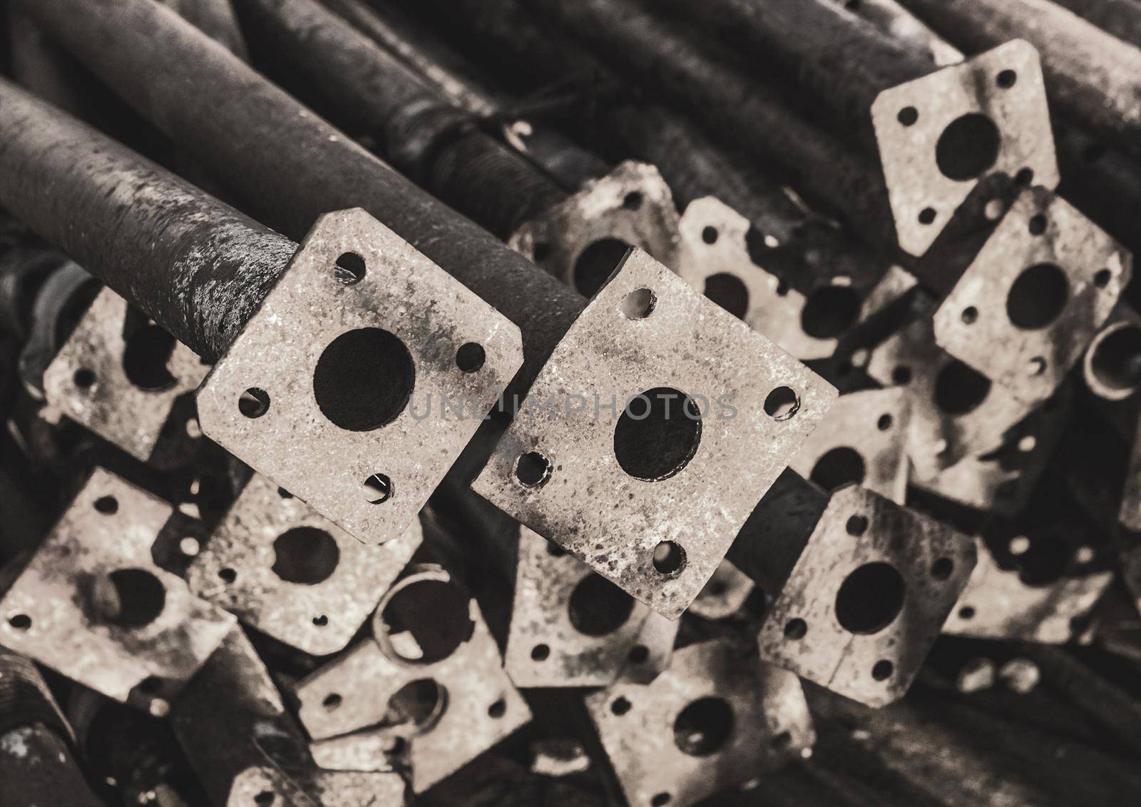 Pile of old industrial temporary fencing pipes at a construction site.