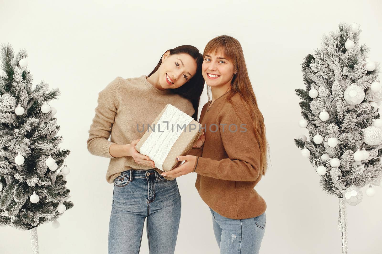 Women with presents. Girl in a brown sweater. Ladies in a studio.