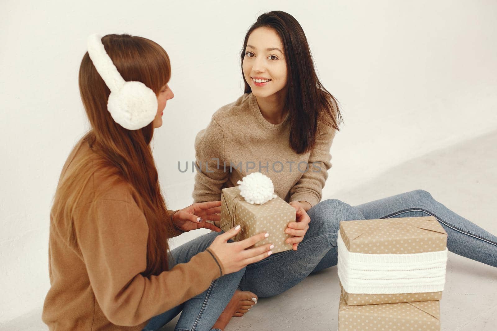 Women with presents. Girls in a brown sweater. Ladies in a studio.