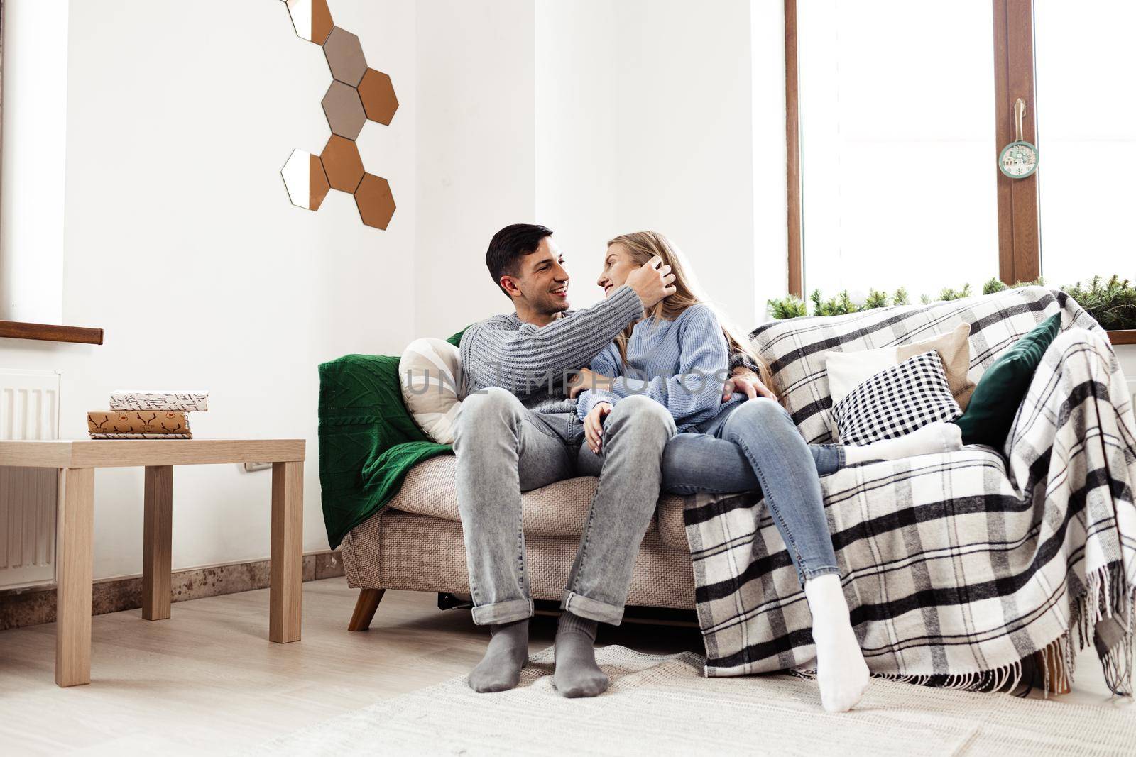 Happy young couple sitting on sofa in living room