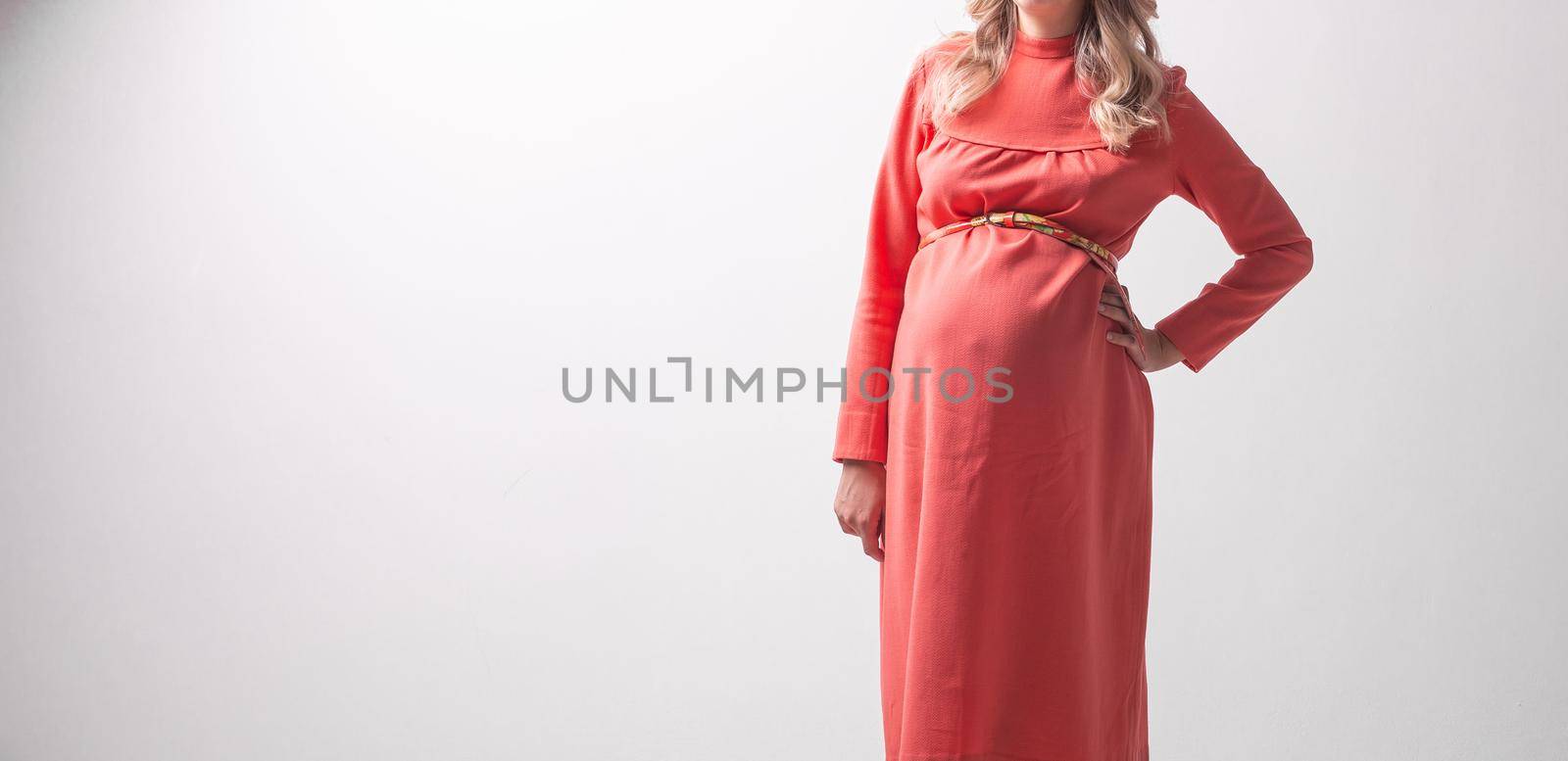 Pregnant woman on white wall background