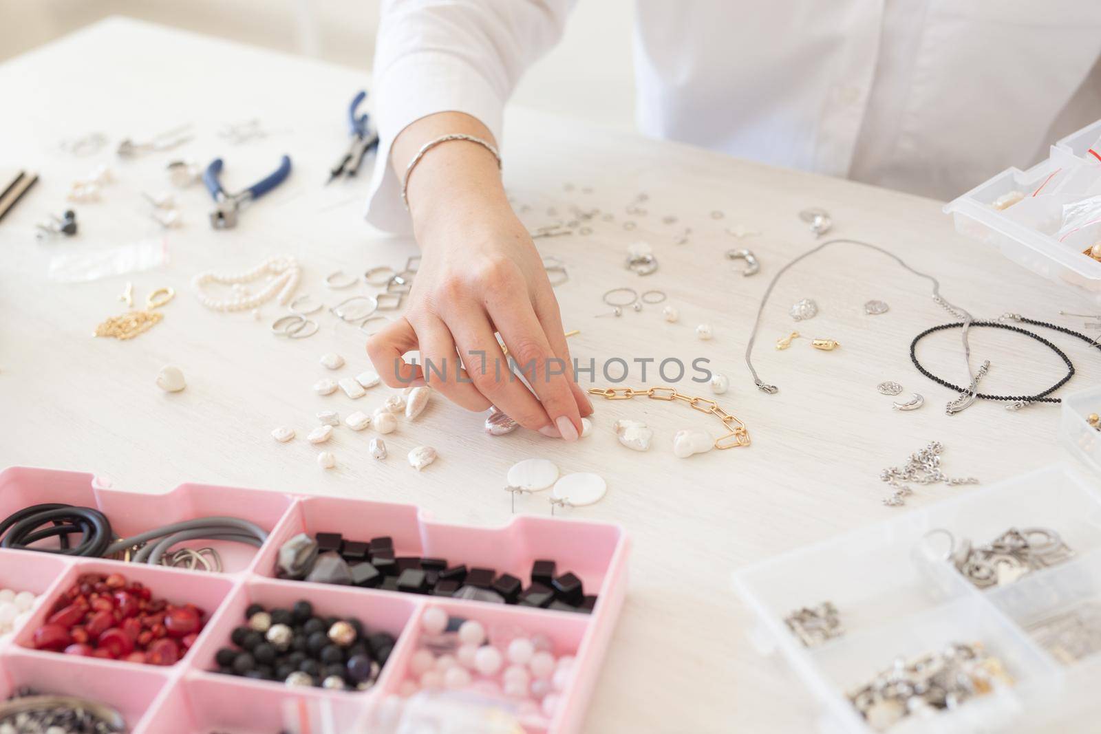 Professional jewelry designer making handmade jewelry in studio workshop. Fashion, creativity and handmade concept.