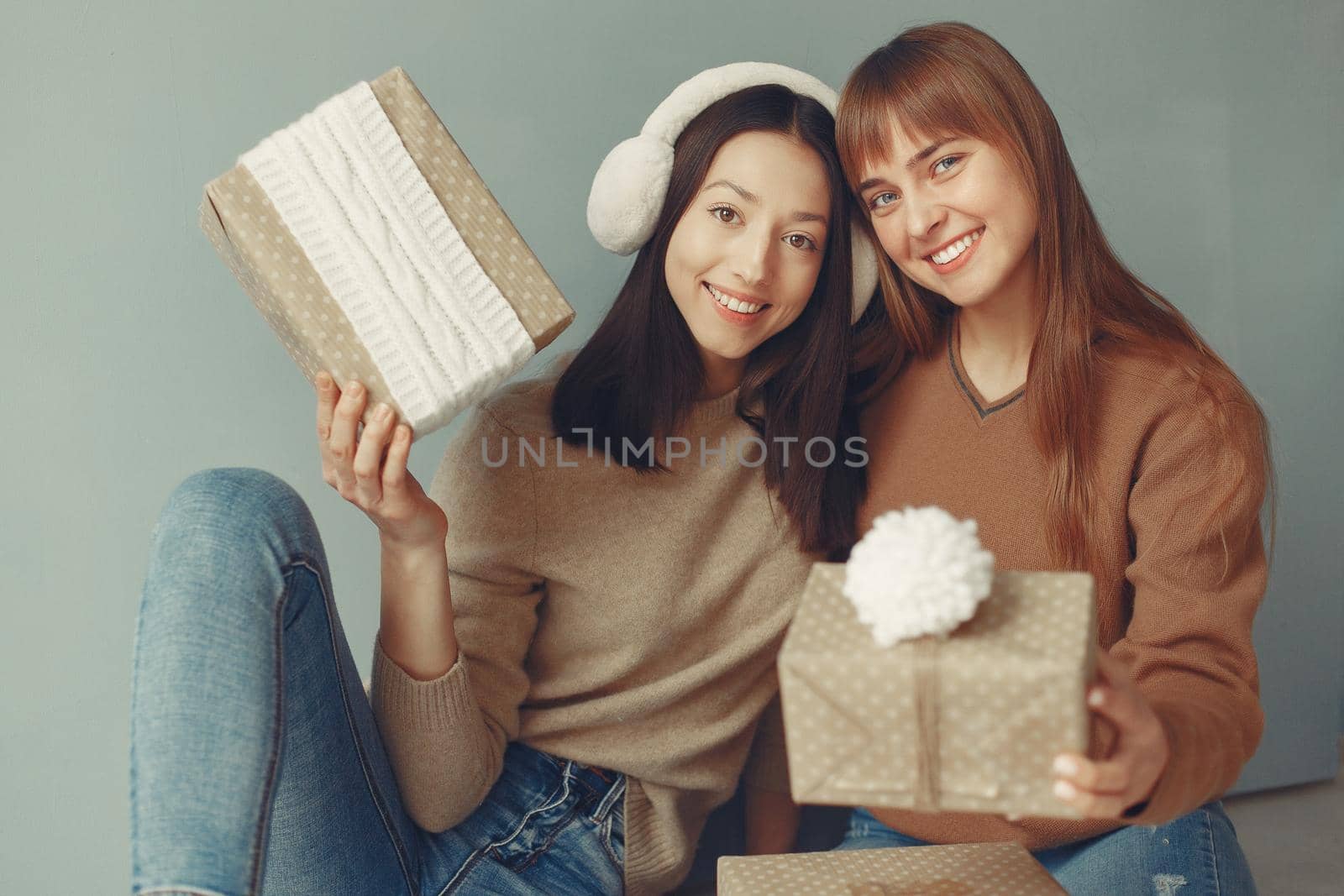 Women with presents. Girls in a brown sweater. Ladies in a studio.