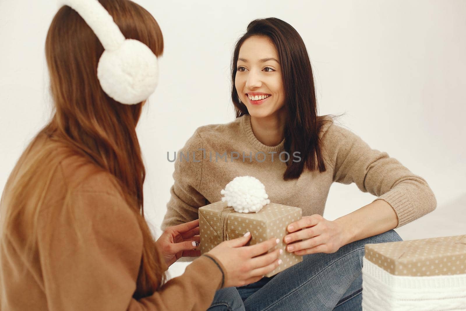 Women with presents. Girls in a brown sweater. Ladies in a studio.