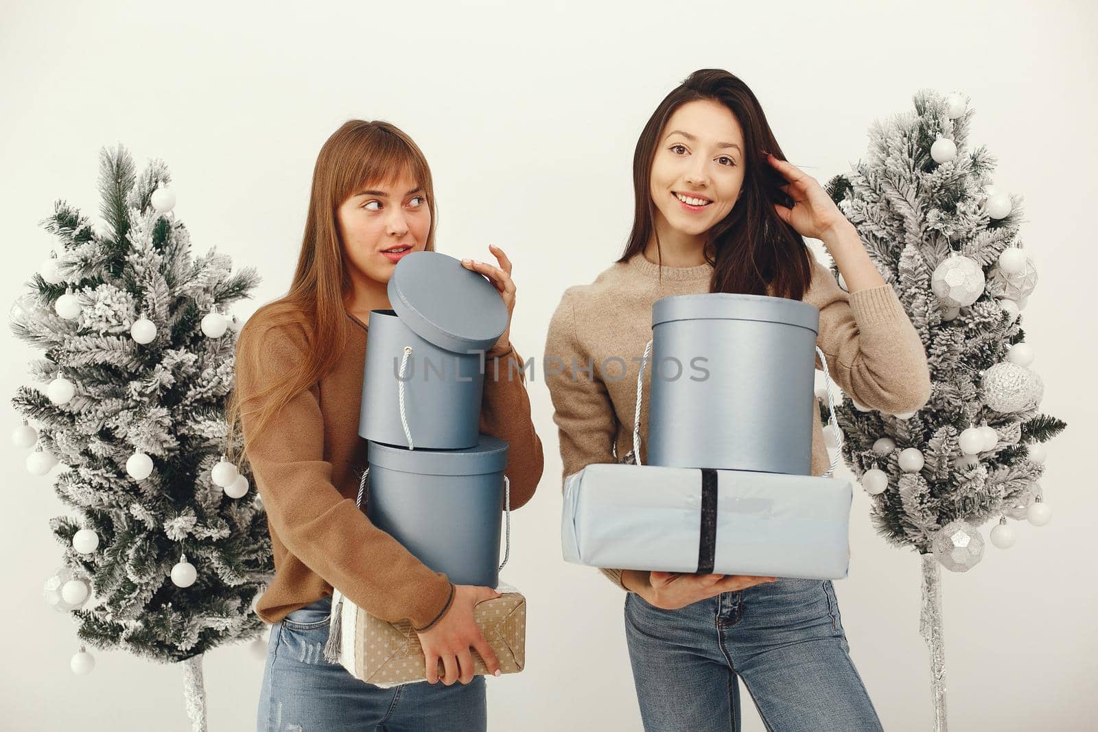 Women with presents. Girl in a brown sweater. Ladies in a studio.