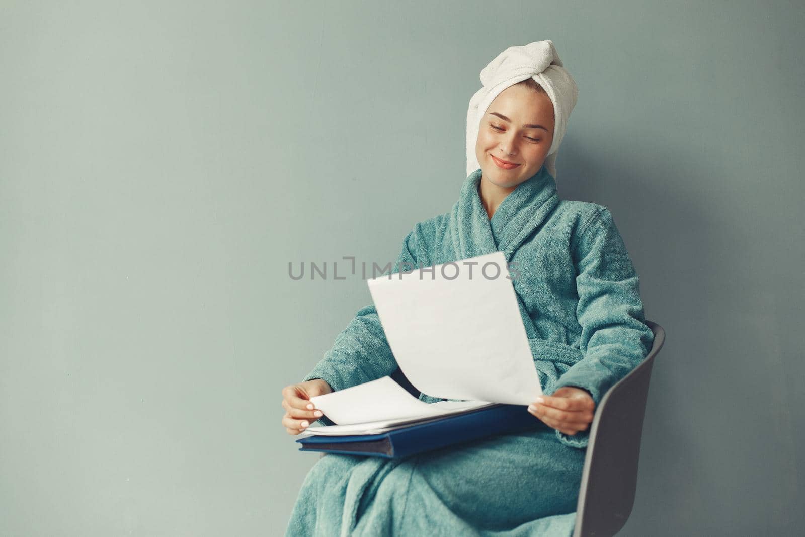 Girl in a studio. Lady in a blue bathrobe. Woman with a documents