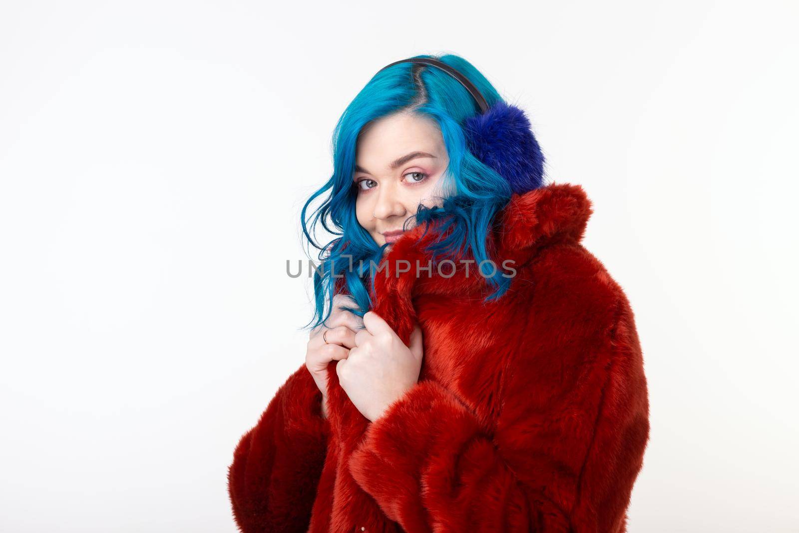 People, protection animals and fashion concept - Beautiful girl with blue hair dressed in red warm jacket in artificial fur and earmuffs.