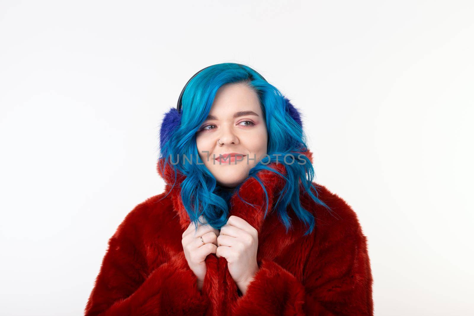 People, protection animals and fashion concept - Beautiful girl with blue hair dressed in red warm jacket in artificial fur and earmuffs by Satura86