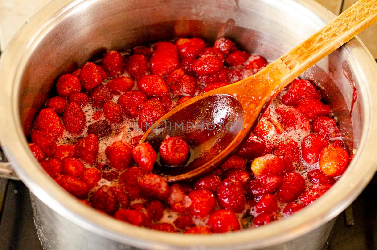 Strawberries are boiled with sugar in pan. Studio Photo