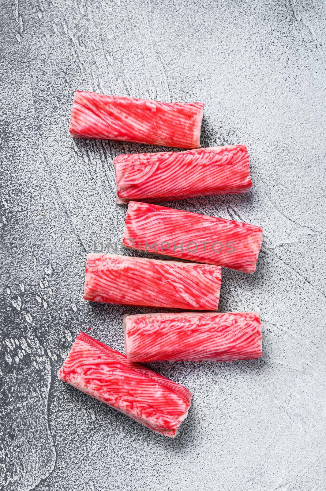 Crab surimi sticks on kitchen table. White background. Top view.