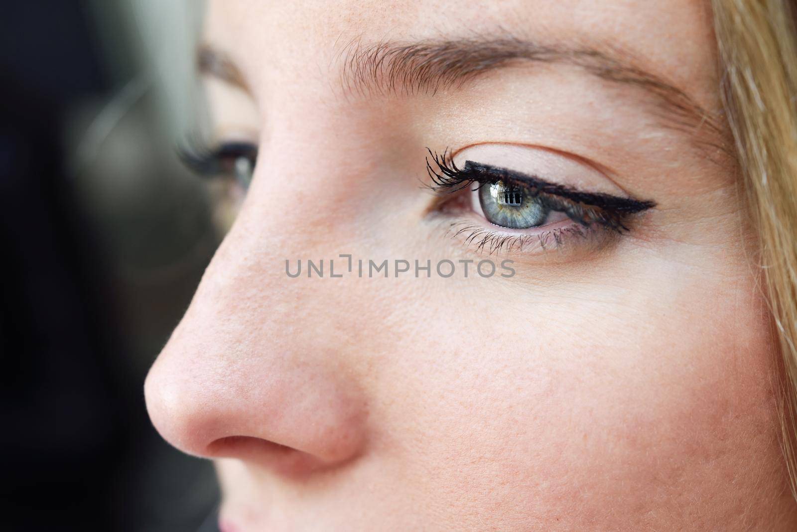 Close-up shot of young woman's eye. Woman with blue eyes.
