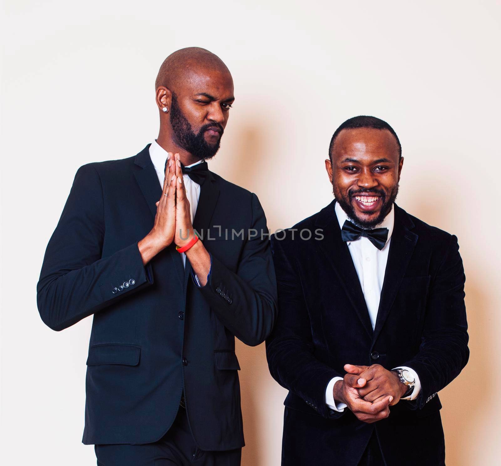 two afro-american businessmen in black suits emotional posing, gesturing, smiling. wearing bow-ties close up
