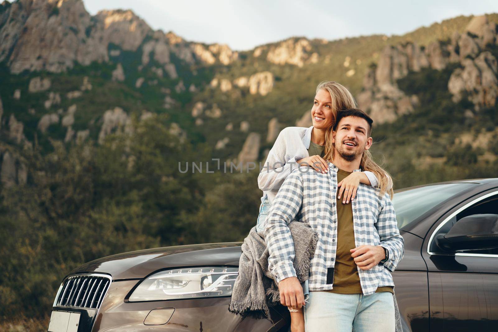 Young couple is on romantic trip to the mountains by car, close up
