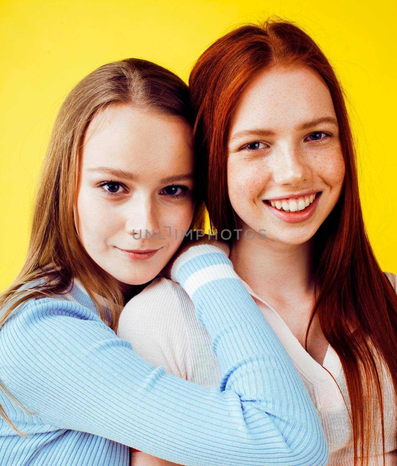 lifestyle people concept: two pretty young school teenage girls having fun happy smiling on yellow background closeup