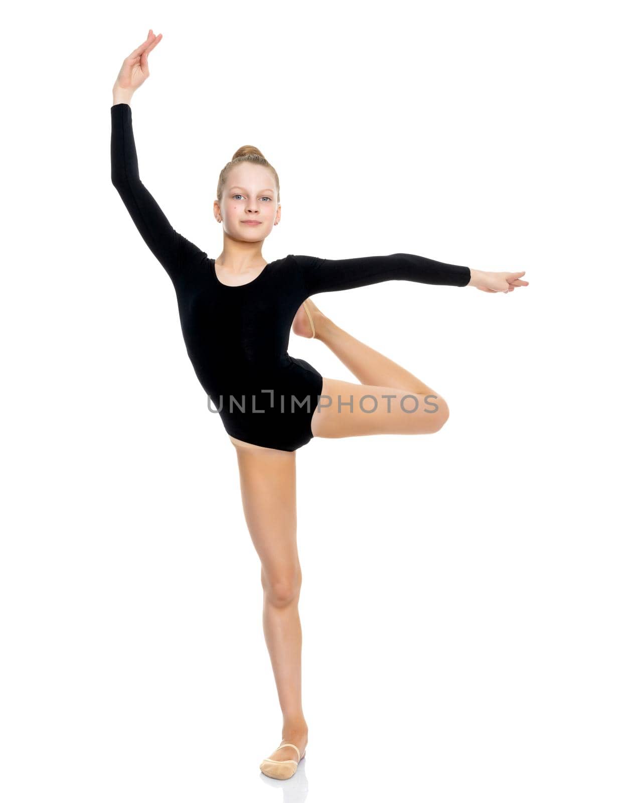 A girl gymnast balances on one leg.The concept of childhood, sport, a healthy lifestyle. Isolated on white background.