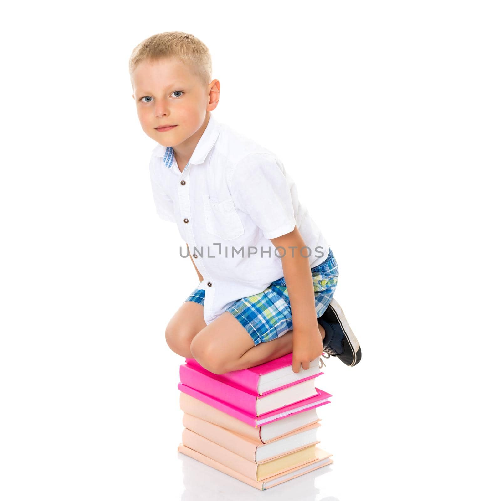 A cute little boy, a preschooler with books. The concept of education, the intellectual development of the child in the family. Isolated on white background.