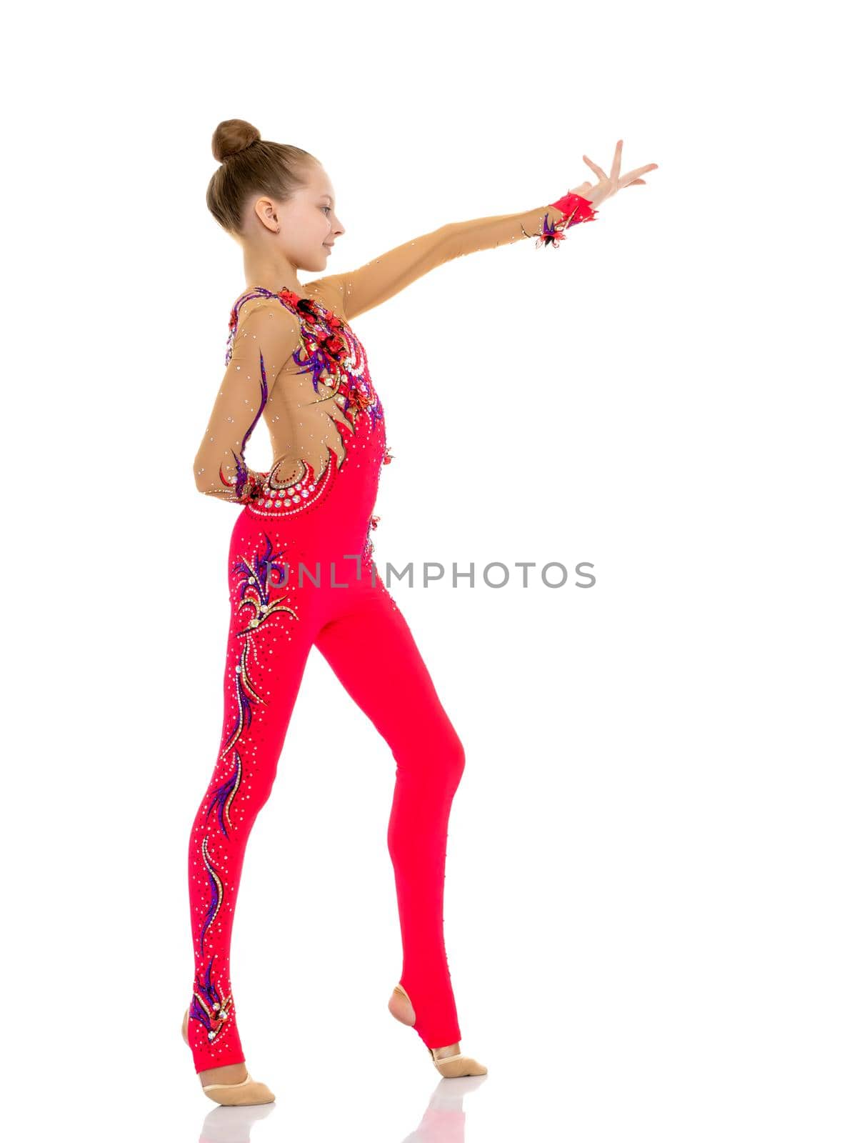 A gymnast girl prepares for the exercise. The concept of childhood and sport, a healthy lifestyle. Isolated on white background.