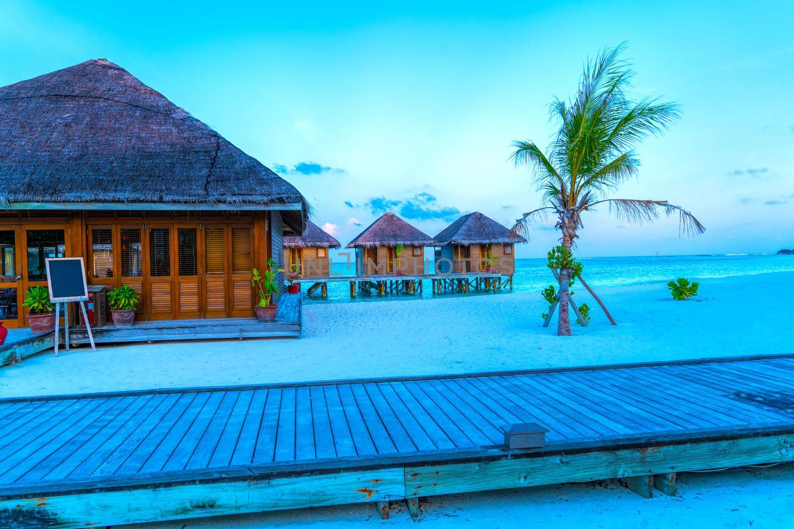 Water Villas,Bungalows and wooden bridge at Tropical beach in the Maldives at summer day.Tourism concept.
