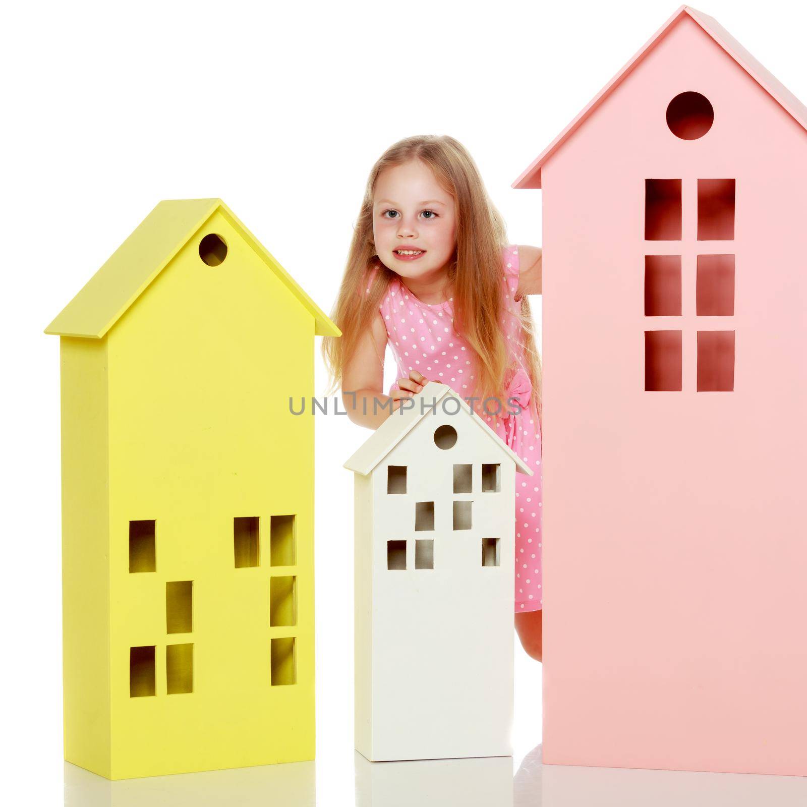 Little girl is playing with wooden houses. by kolesnikov_studio