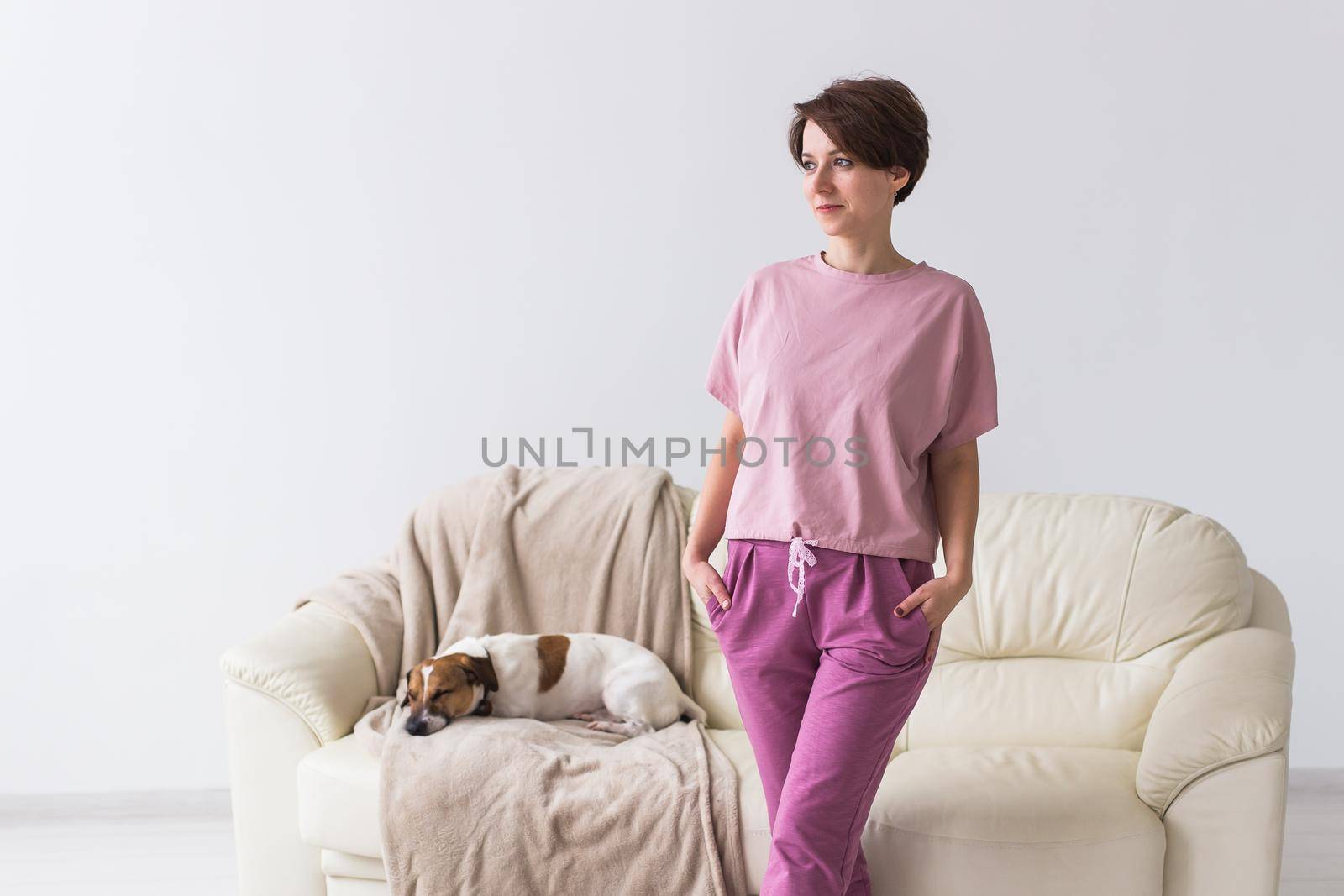 Young attractive woman dressed in beautiful colorful pajama posing as a model in her living room. Comfortable sleepwear, home relaxation and female fashion concept