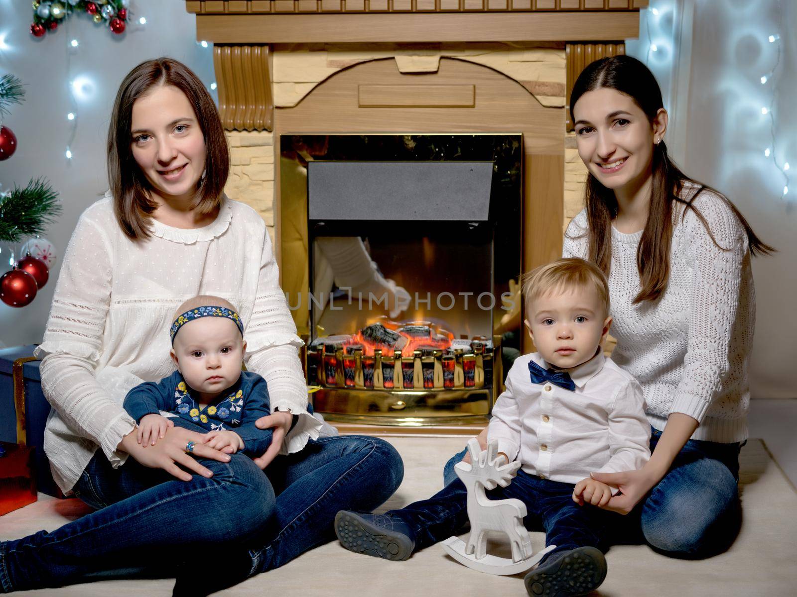 Mom with children in the New Year by the fireplace. by kolesnikov_studio