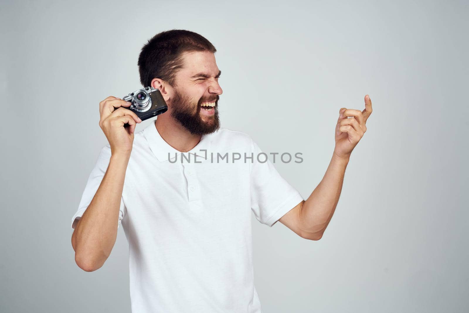man holding camera professional photographer home light background by Vichizh