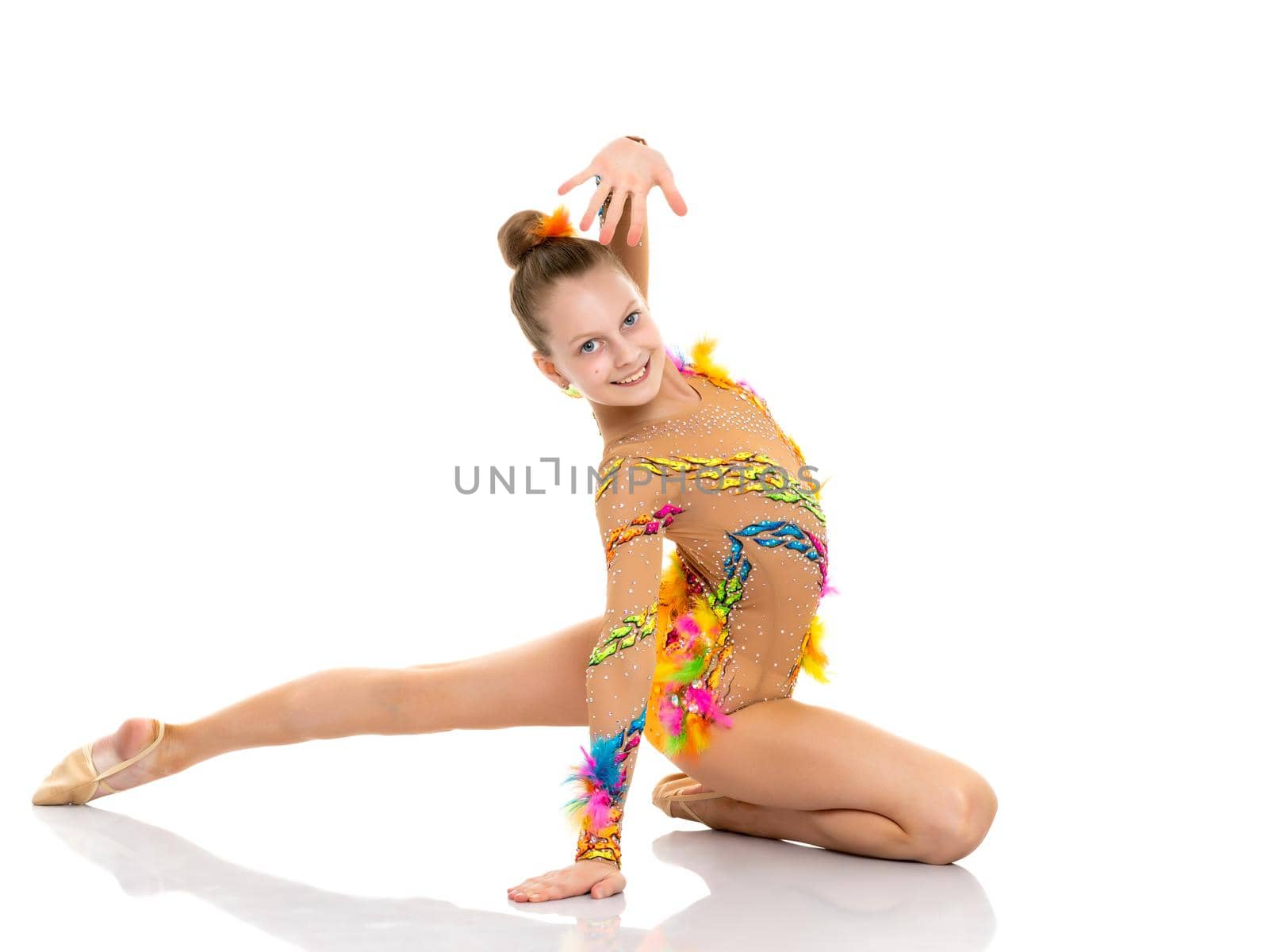 A girl gymnast performs an acrobatic element on the floor. The concept of childhood, sport, healthy lifestyle. Isolated on white background.