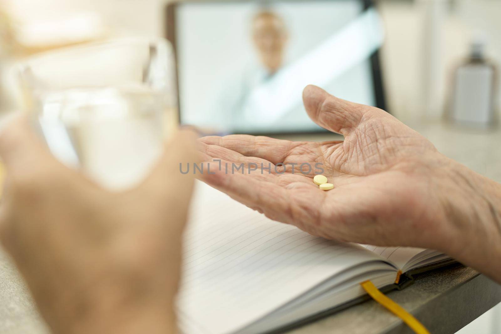 Senior man preparing to take pills with water by friendsstock