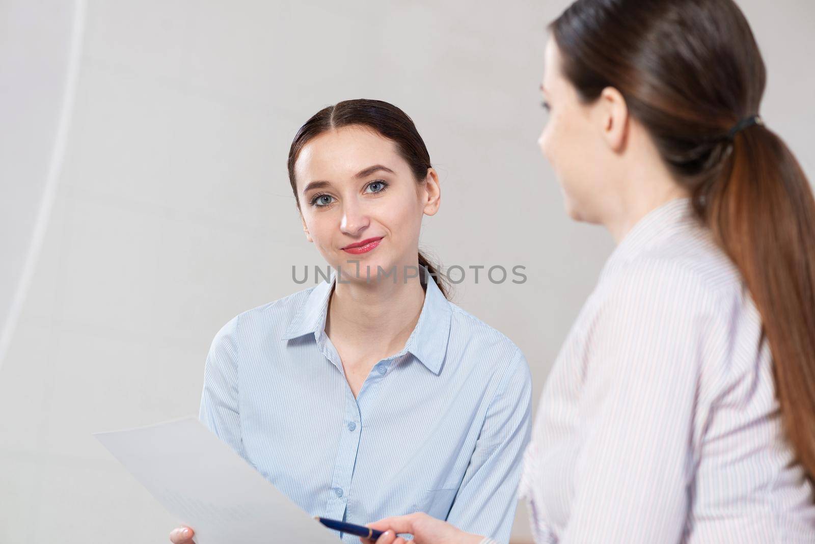 Young attractive woman talks to a colleague in the office by adam121