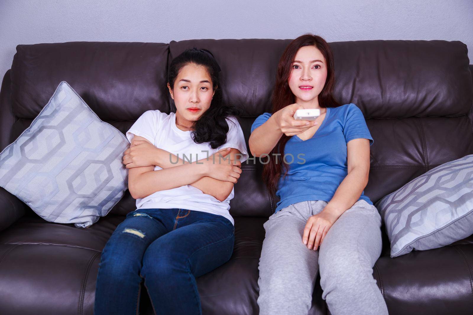 two woman hand hold remote air conditioner on sofa at home by geargodz