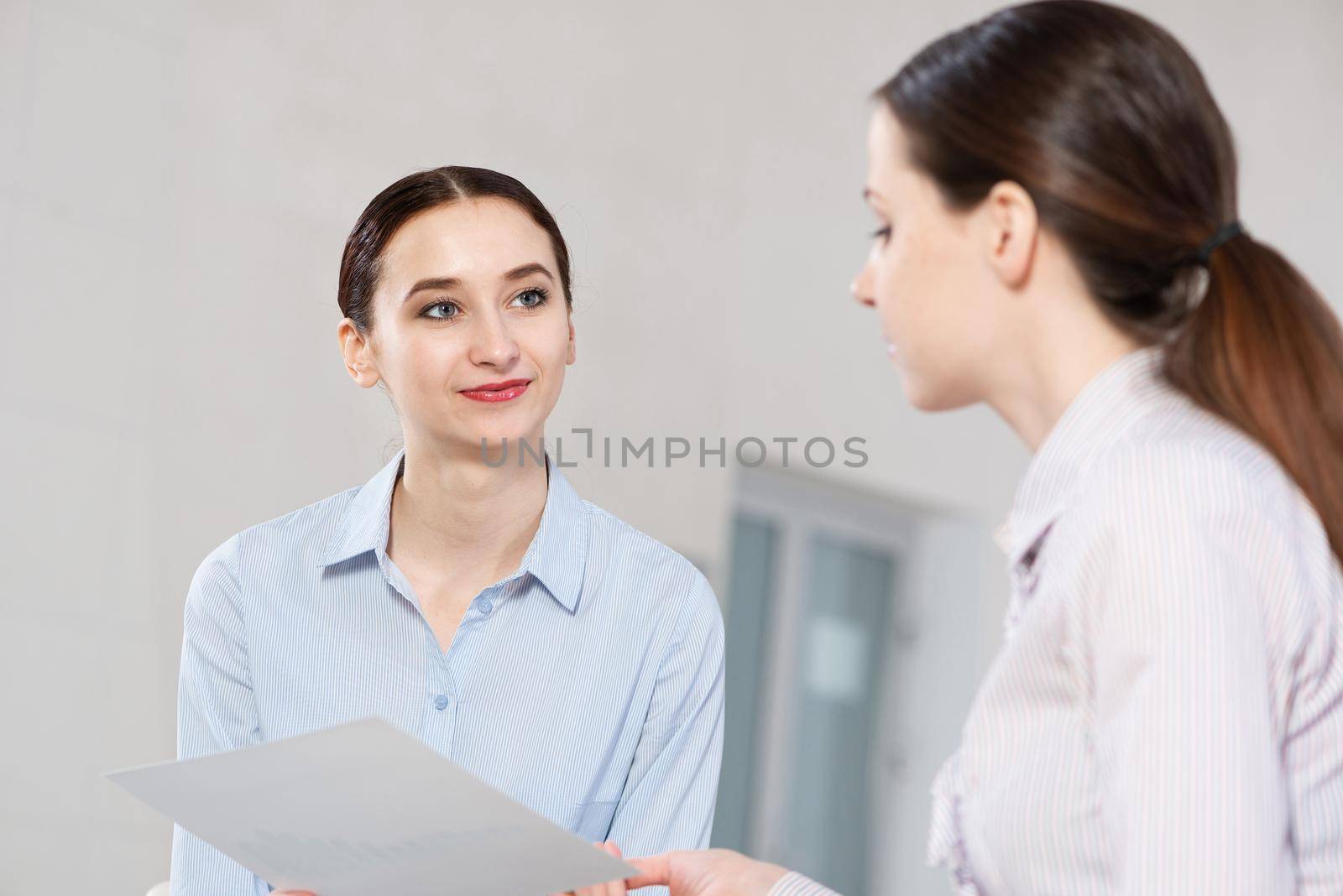 Young attractive woman talks to a colleague in the office by adam121