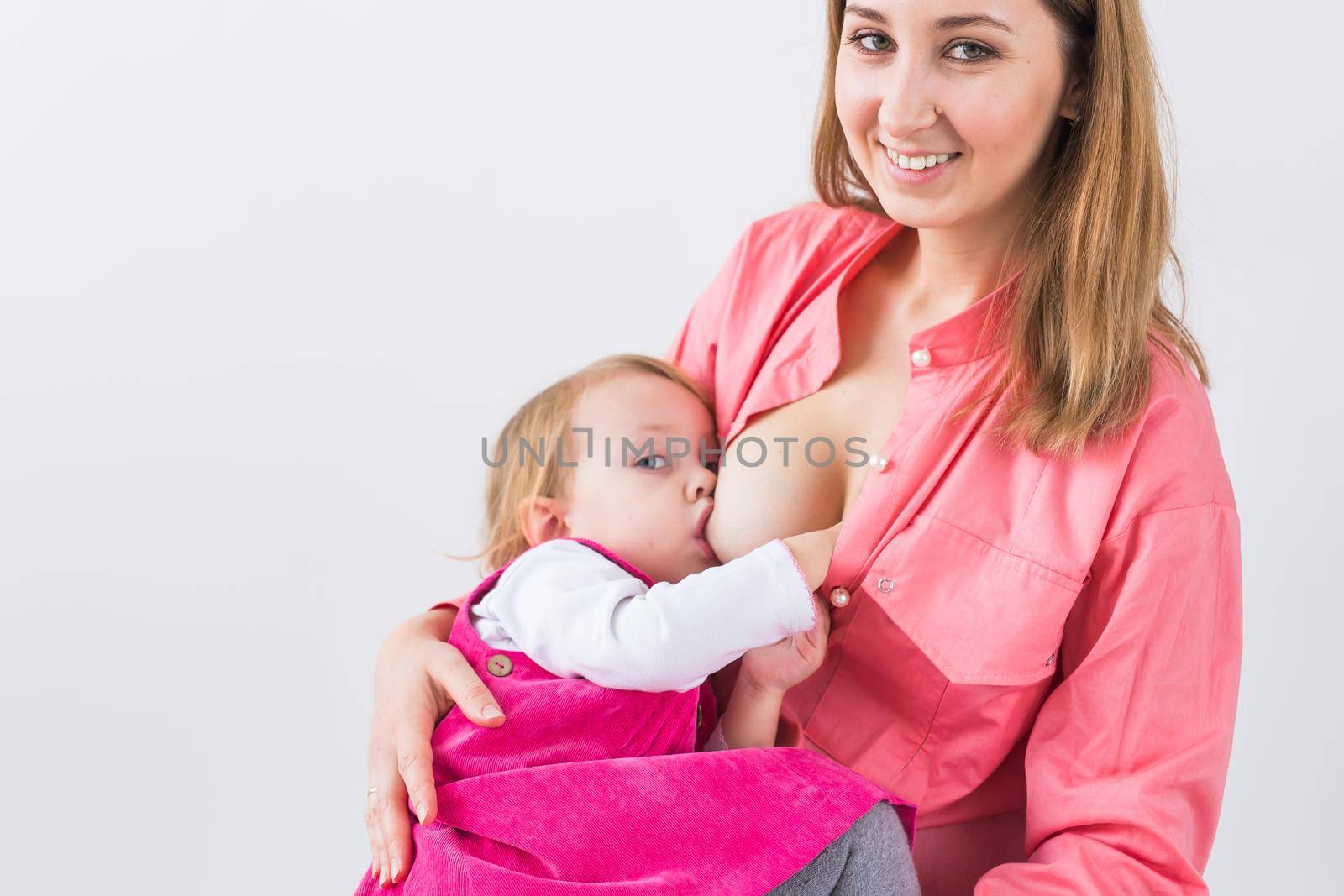 Young beautiful mother, breastfeeding her baby girl. Mom breastfeeding infant.