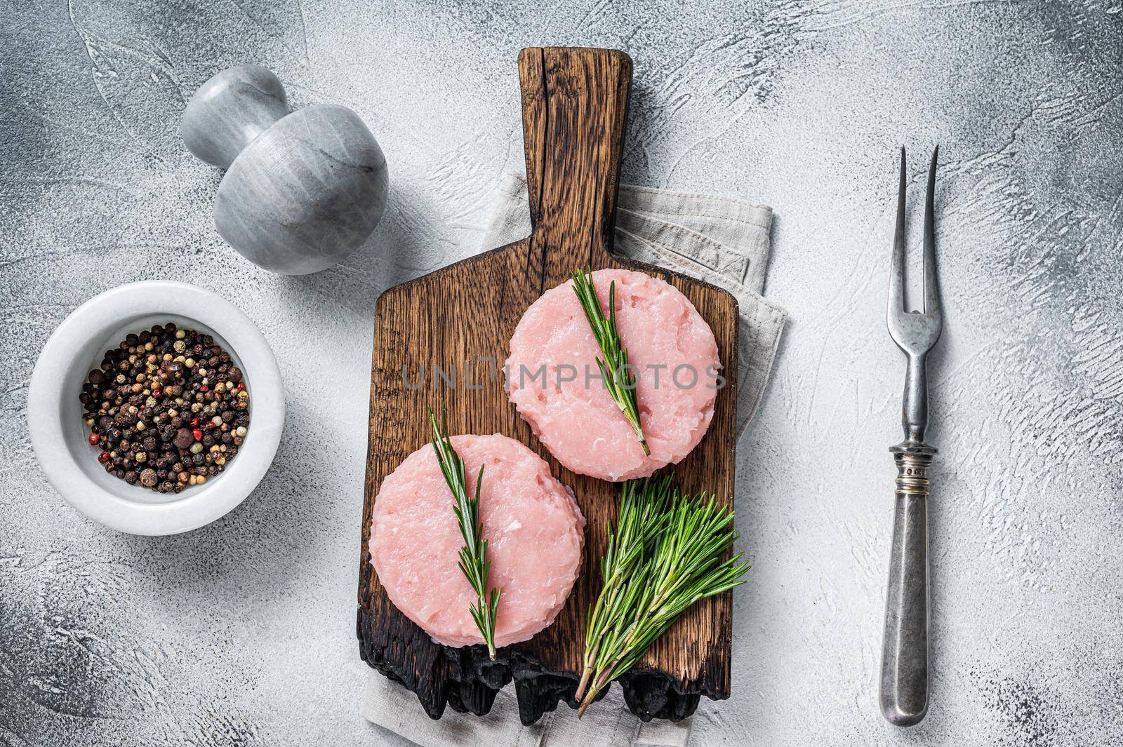 Uncooked Raw mince meat patty cutlet with herbs. White background. Top view.